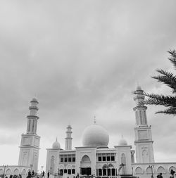 Low angle view of buildings against cloudy sky