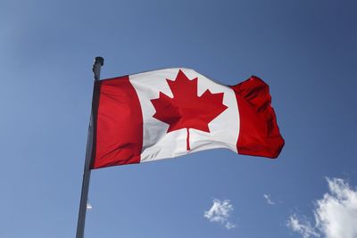 Low angle view of red flag against blue sky