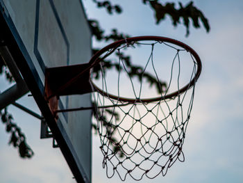 An old outdoor basketball hoop and net in school, in the evening when no one plays