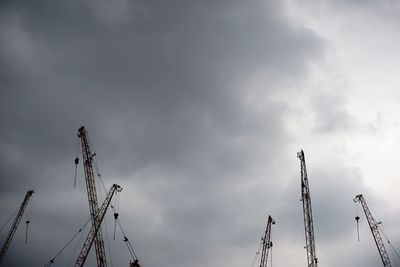 Low angle view of cranes against sky