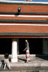 Rear view of people walking on building