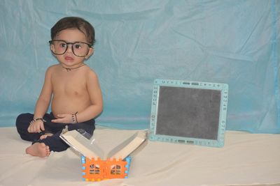 Portrait of cute boy playing with toy against wall