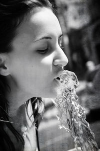 Close-up of young woman by drinking fountain