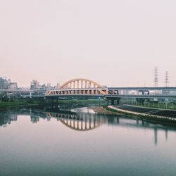 Serene urban scene with bridge and water reflection