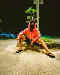 Rear view of man sitting on sofa at night