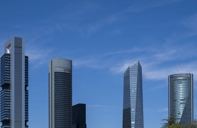 Low angle view of four tower buildings against sky finance area of madrid city, spain. copy space.