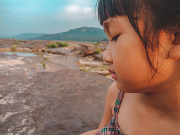 Close-up portrait of girl looking at beach