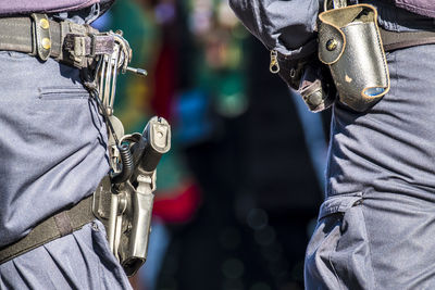 Rear view midsection of police with weapons