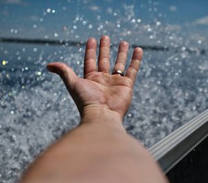 Cropped image of person hand against water