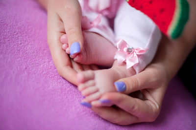 Cropped woman holding daughter legs