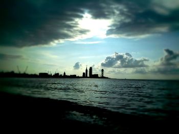 Scenic view of sea against cloudy sky at sunset