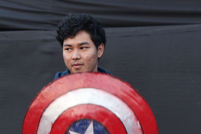 Young man with shield looking away outdoors