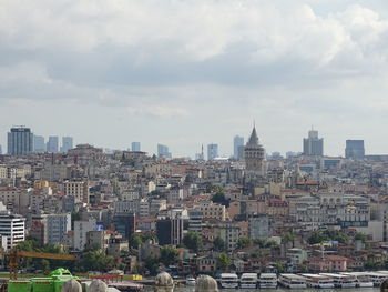 Buildings in city against cloudy sky