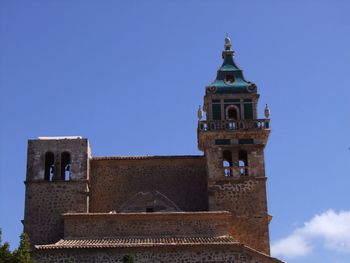 Low angle view of bell tower against blue sky