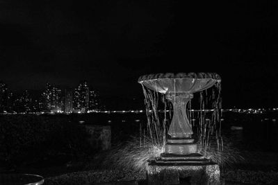 Illuminated built structure against sky at night