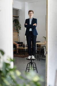 Portrait of a confident businesswoman standing on a stool