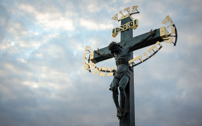 Low angle view of cross against sky