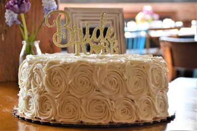 Close-up of bride to be text on cake over table