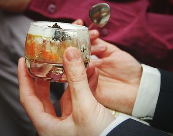 Close-up of hand holding drink with red wine