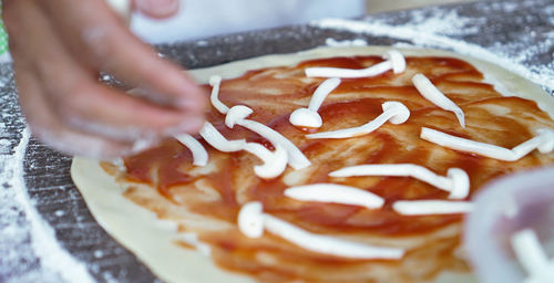 Close-up of hand holding pizza