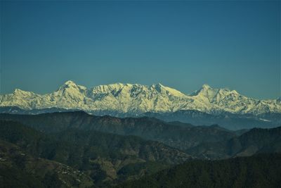Scenic view of snowcapped mountains against clear blue sky