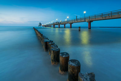 Bridge over calm sea against sky