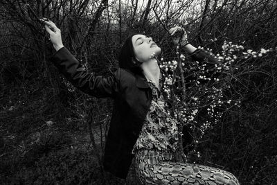 Woman standing by tree on field