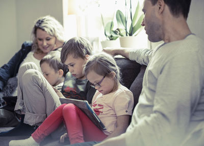 Family of five sitting on sofa at home