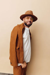 Portrait of man standing against wall