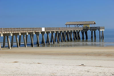 Lifeguard hut on beach against clear blue sky