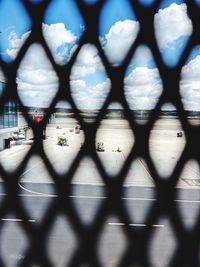 Blurred motion of train seen through chainlink fence