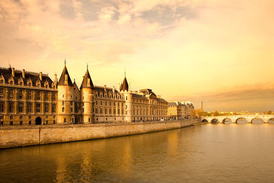 The conciergerie at justice palace and pont neuf bridge over the seine river, paris, france