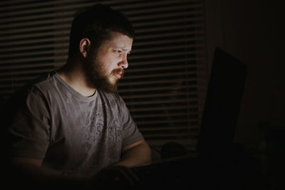 Man using laptop in darkroom