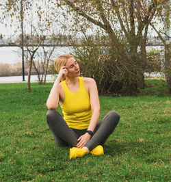 Portrait of young woman exercising on field