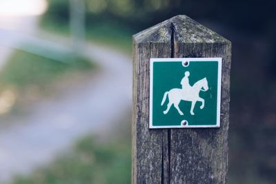 Close-up of sign on wooden post