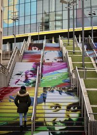 Rear view of people walking on multi colored building