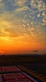 Airplane flying over sea during sunset
