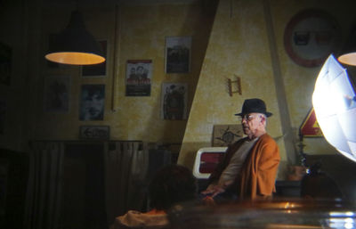 Young man sitting in illuminated room