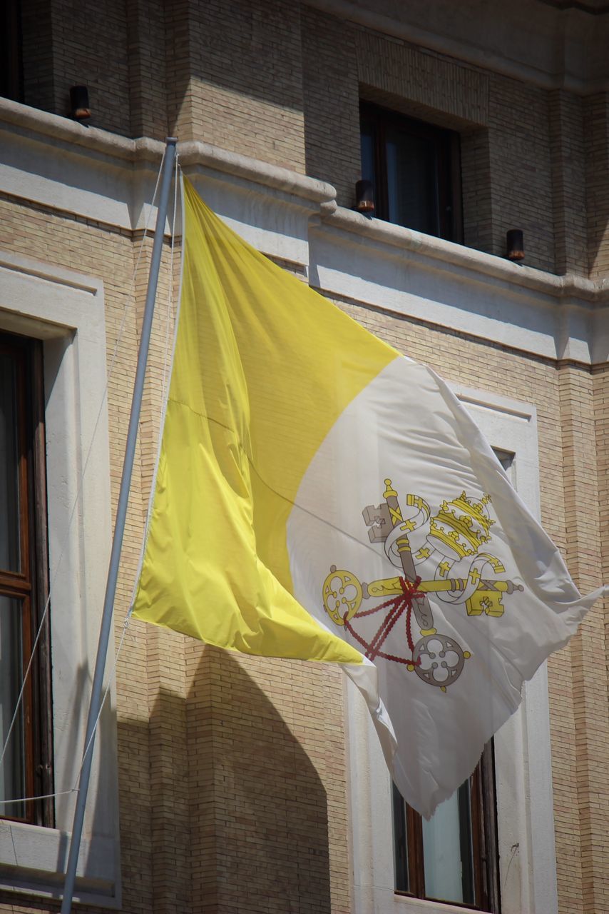 yellow, architecture, building exterior, built structure, no people, flag, window, building, day, art, nature, outdoors, low angle view, hanging, house, city, patriotism