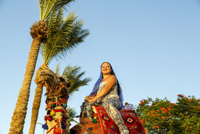 Low angle view of woman against clear sky