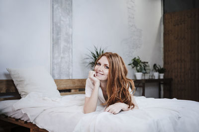 Young woman lying down on bed at home