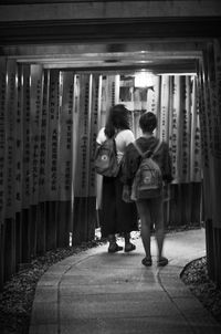 Rear view of people standing in illuminated corridor