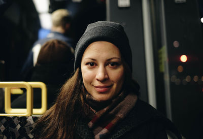 Close-up portrait of woman sitting in bus at night