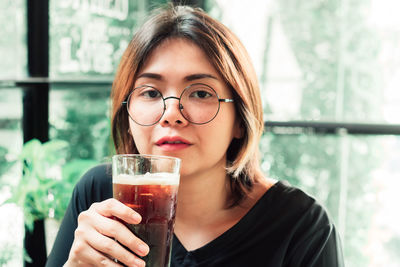 Portrait of young woman drinking glass