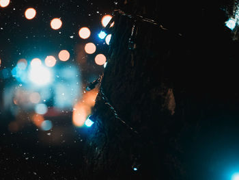 Close-up of wet illuminated glass at night