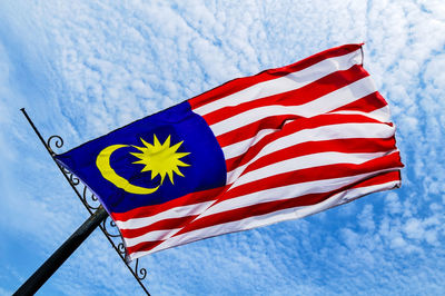 Low angle view of flag against blue sky