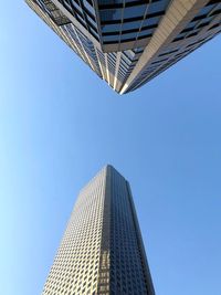 Low angle view of modern building against blue sky