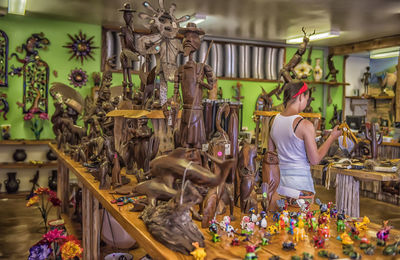 Rear view of woman with flowers in shop