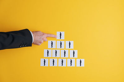 Close-up of a hand against yellow background