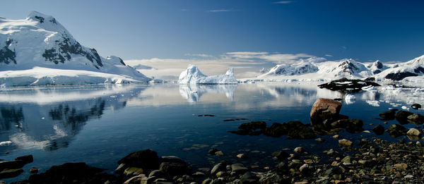 Scenic view of icebergs in lake against sky